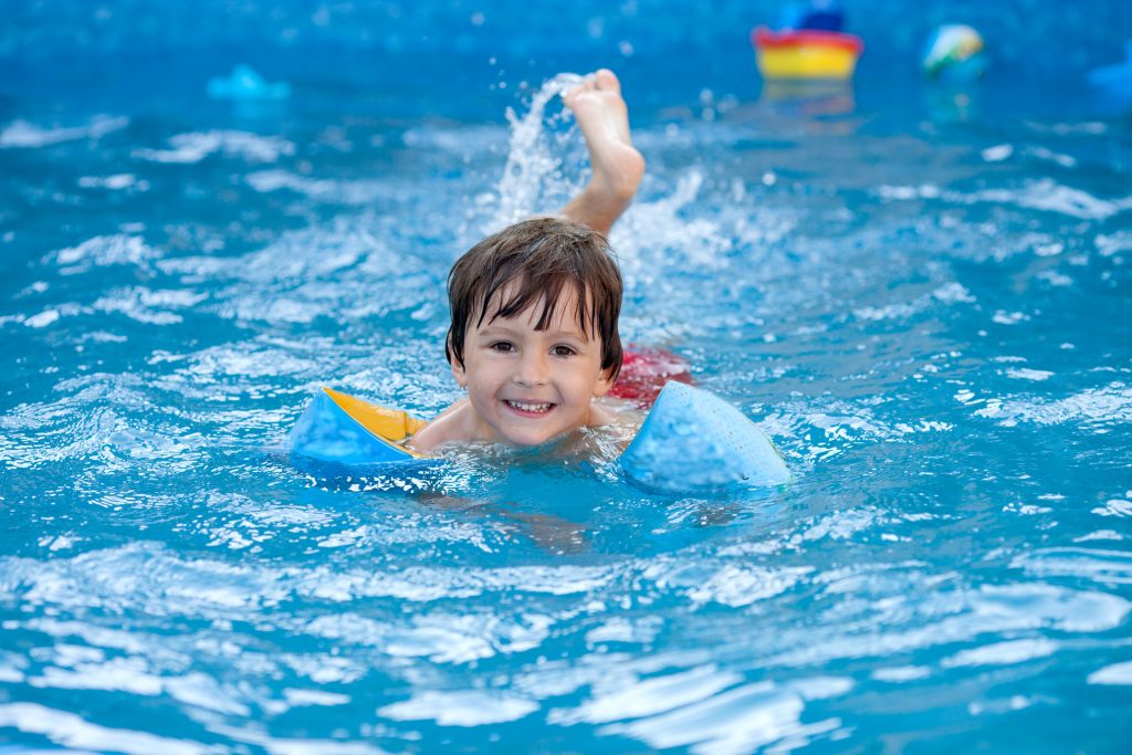 Sweet little boy, swimming in big swimming pool Autism Society of